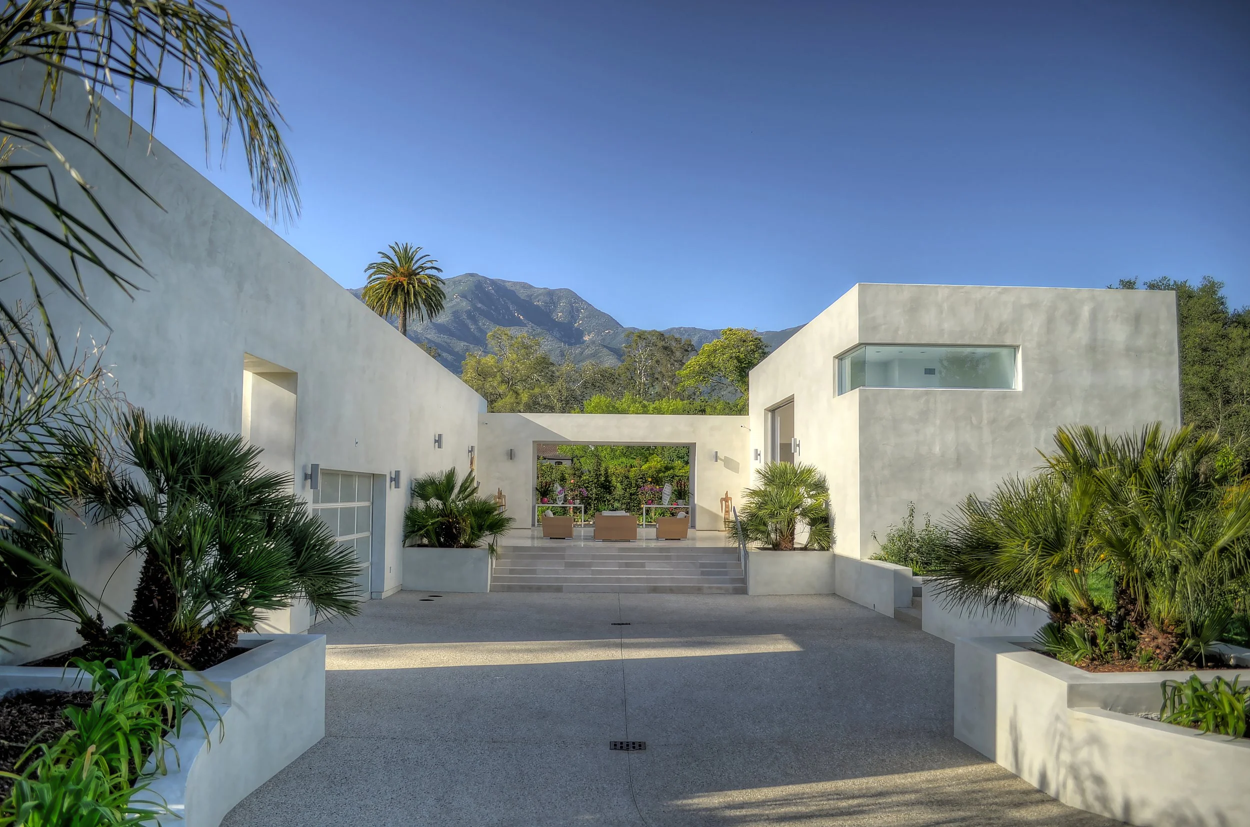 Framing the distant mountain landscape, this courtyard at the Demetrios Residence beautifully integrates The Warner Group Architects, Inc.'s modern design with the natural surroundings.