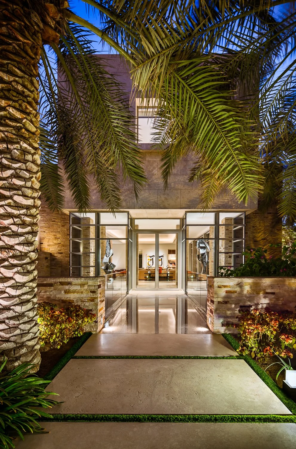 Elegant entrance of a luxury villa surrounded by palm trees, showcasing modern architectural design, Kuwait Estate.