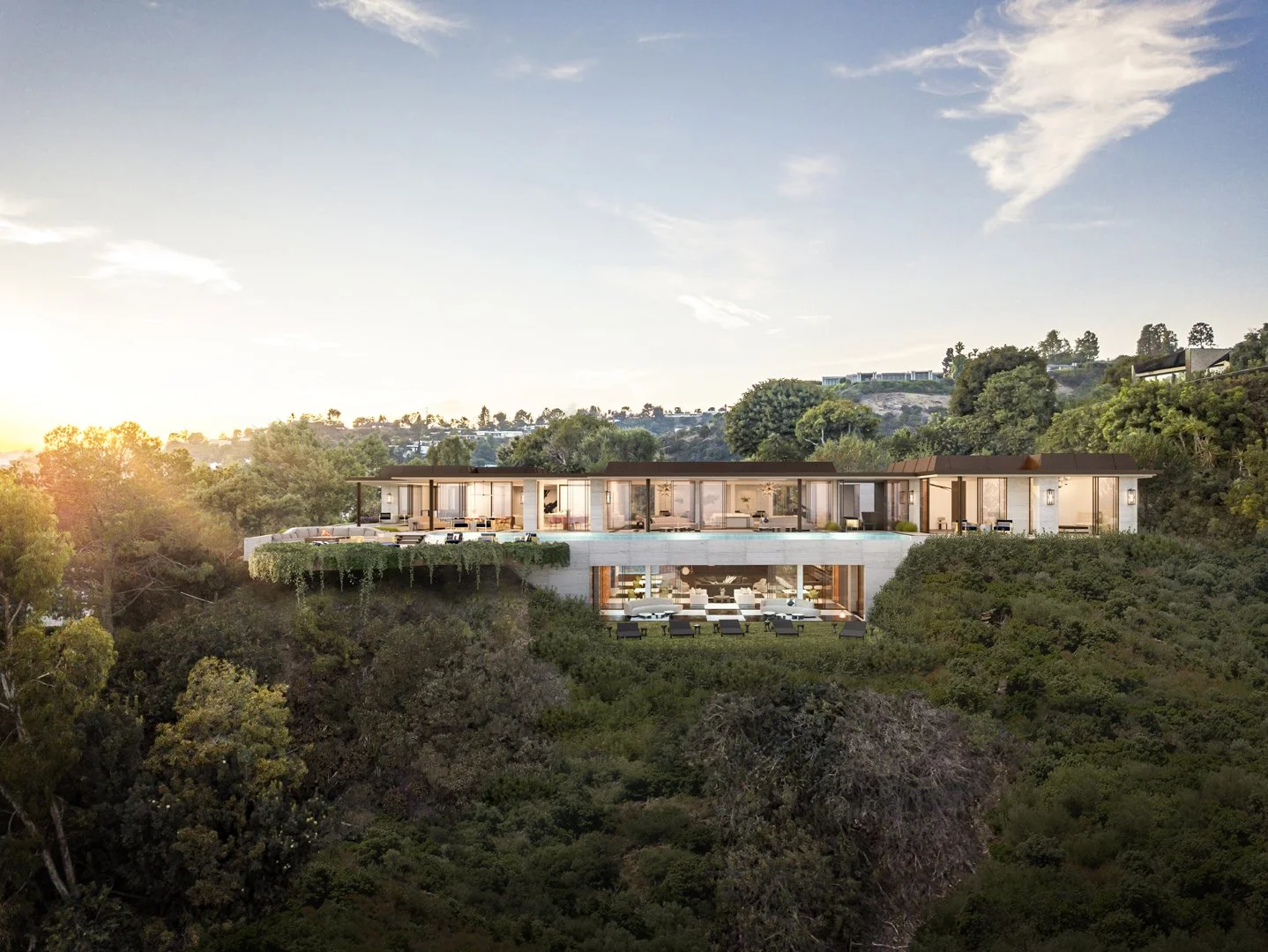 Modern luxury hillside mansion with large glass windows and expansive terraces, surrounded by lush greenery, under a clear sky.