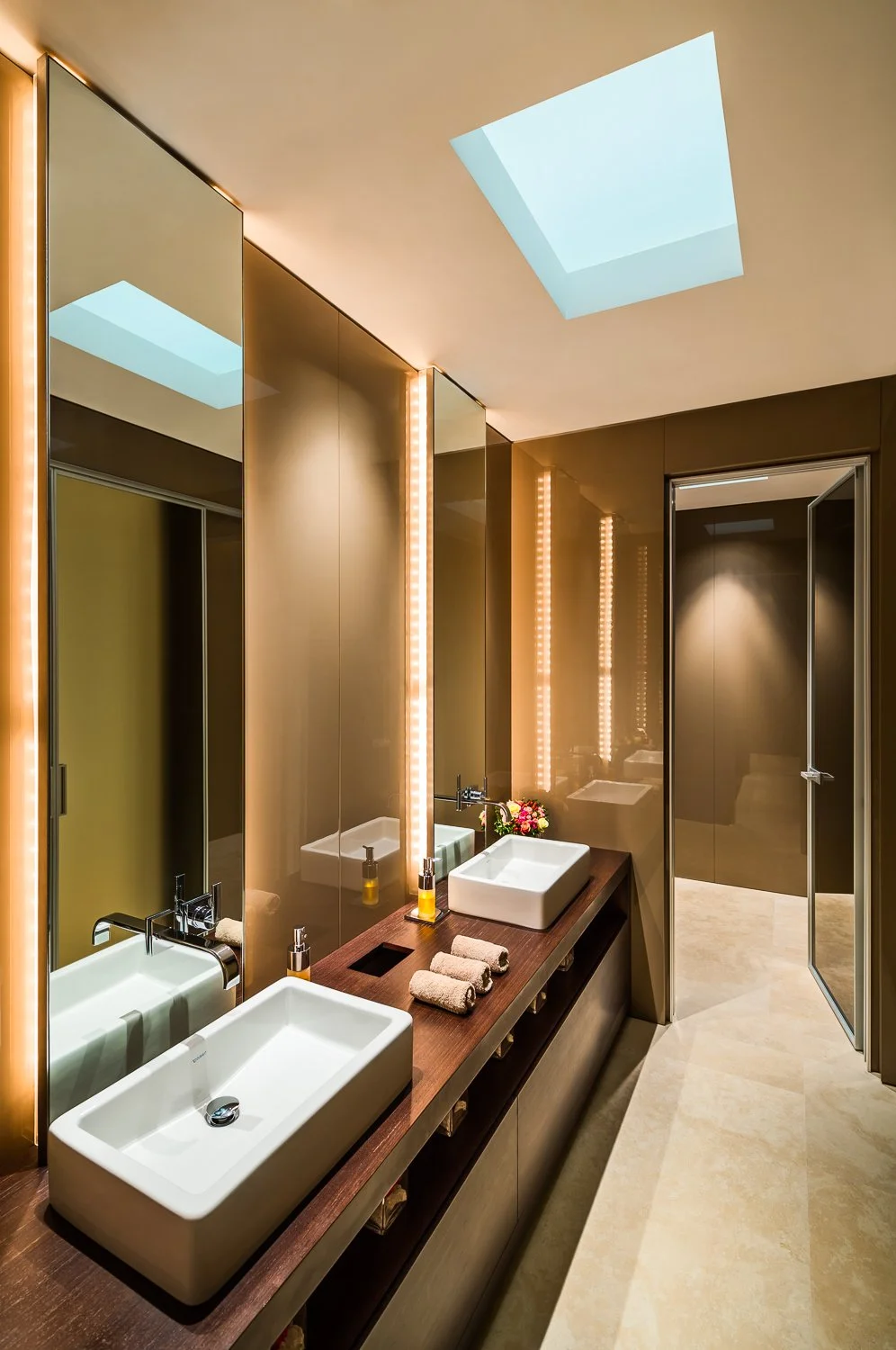 Contemporary bathroom with skylight and dual sinks.